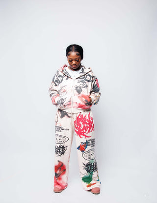 Model wearing oversized GRAFFITI SWEATS with all over print design, featuring a cropped zip-up and 500 GSM wide-leg pants.