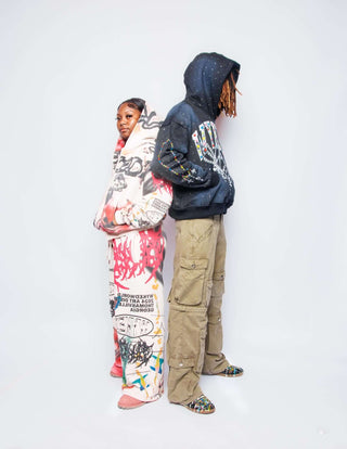 Fashionable couple wearing GRAFFITI SET, featuring all-over print cropped zip-ups and cargo pants.